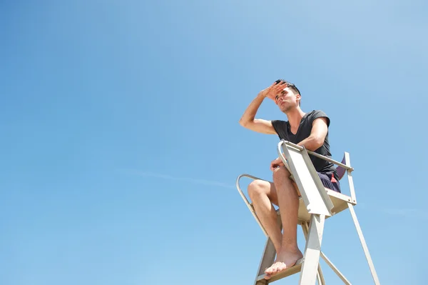 Leven bewaker zittend in stoel op zoek in de verte — Stockfoto