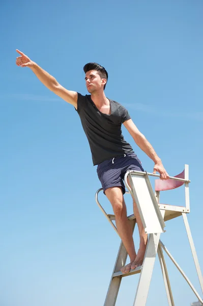 Male lifeguard pointing outdoors — Stock Photo, Image