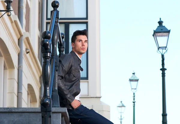 Yakışıklı bir genç adam açık havada oturma portre — Stok fotoğraf