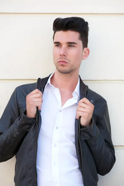 Attractive male fashion model holding black leather jacket — Stock Photo, Image