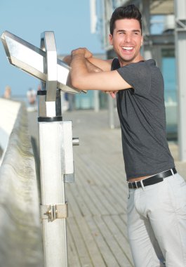 açık havada gülümseyerek mutlu bir genç adam