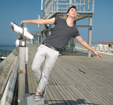 Happy young man with arms spread