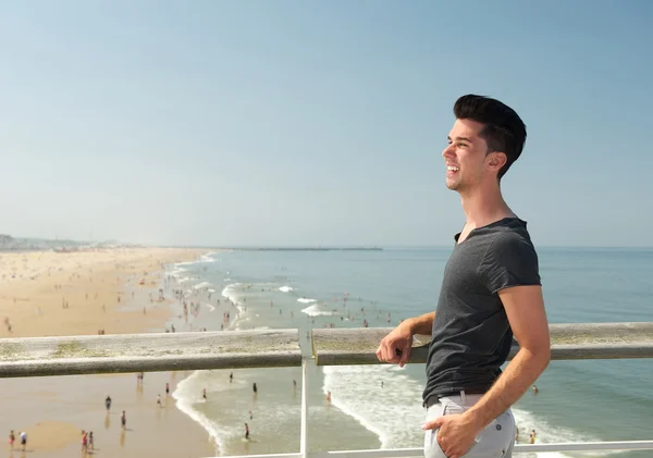 Молодий чоловік посміхається на пляжі — стокове фото