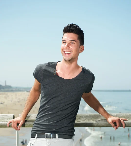 Porträt eines attraktiven jungen Mannes, der am Strand lächelt — Stockfoto