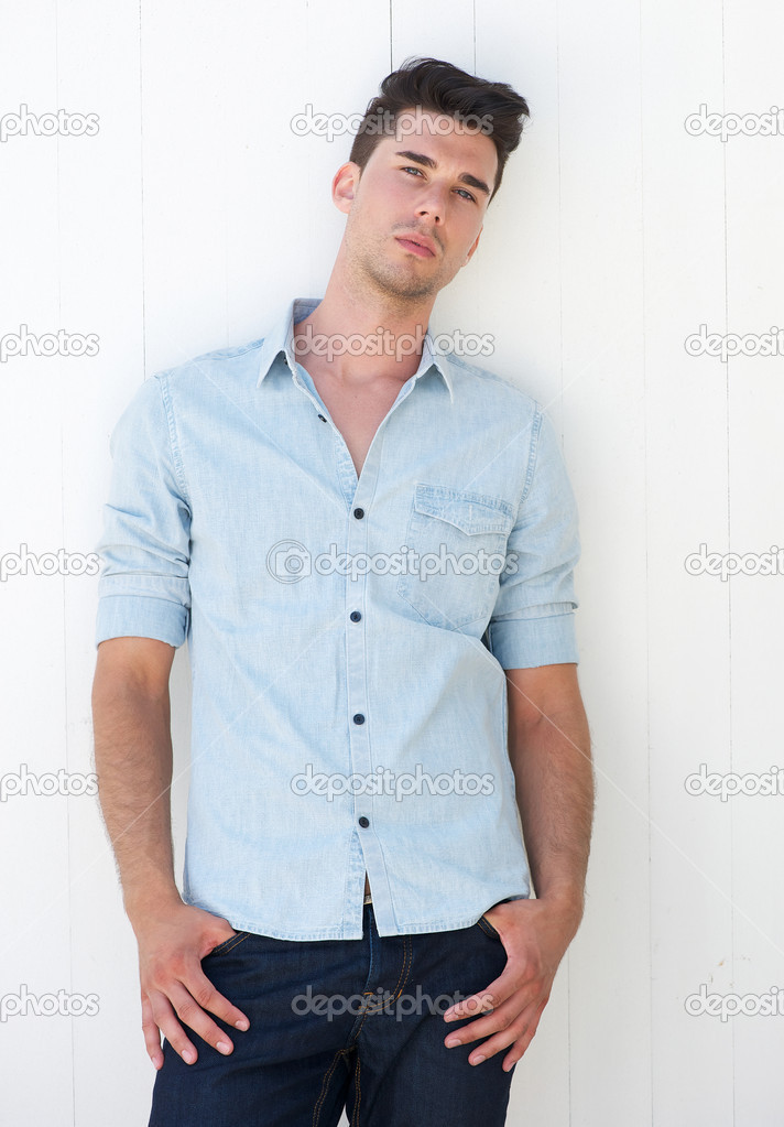 Attractive young man standing outdoors with hands in pocket