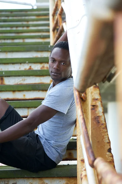 Όμορφος αφρικανική αμερικανική άνθρωπος που κάθεται σε σκαλοπάτια σε εξωτερικούς χώρους — Φωτογραφία Αρχείου