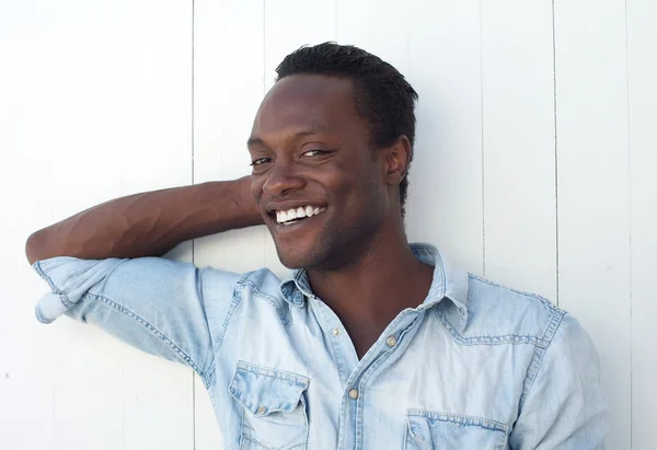 Feliz joven negro sonriendo sobre fondo blanco al aire libre —  Fotos de Stock