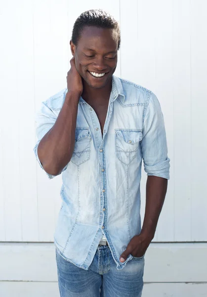 Sorrindo homem negro de pé ao ar livre contra fundo branco — Fotografia de Stock