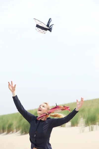 Mujer mayor con viento soplando sombrero de distancia — Foto de Stock