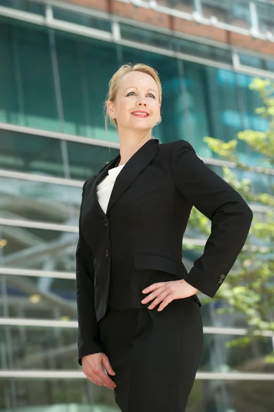 Femme d'affaires confiante souriant à l'extérieur du bâtiment de bureaux — Photo