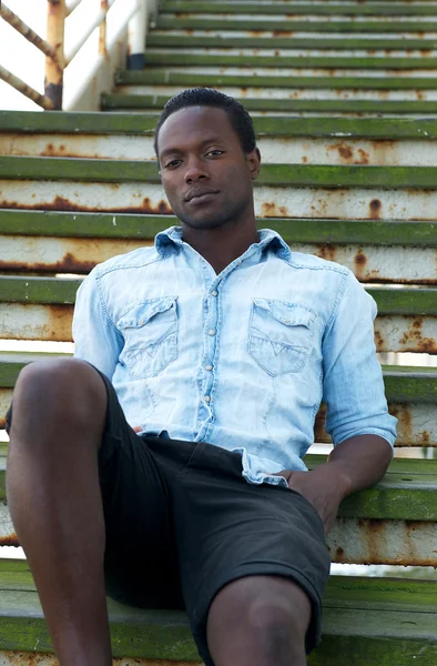 Handsome african american man sitting on stairs outdoors — Stock Photo, Image