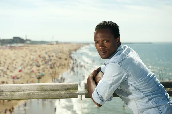 Αφρικανική αμερικανική άνθρωπος που χαλαρώνοντας στην παραλία σε μια καλοκαιρινή μέρα — Φωτογραφία Αρχείου