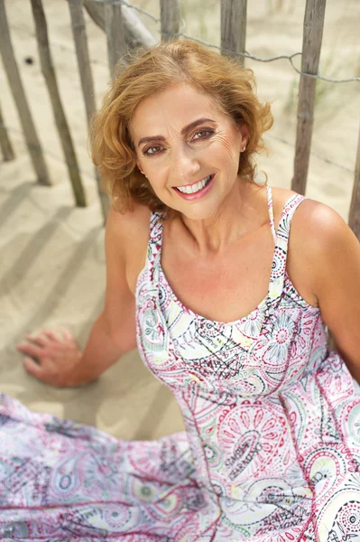 Mulher de meia idade sorrindo na praia — Fotografia de Stock