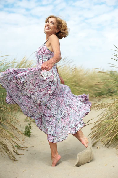 Femme plus âgée active dansant à la plage — Photo