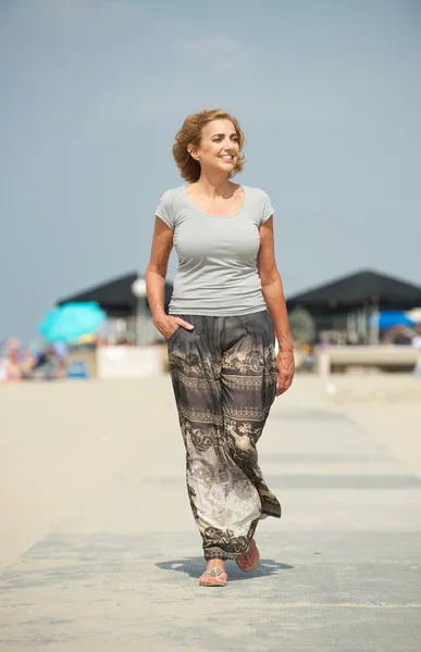 Meautiful older woman walking at the beach — Stock Photo, Image