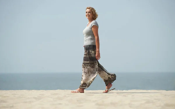 Potret seorang wanita dewasa berjalan di pantai — Stok Foto