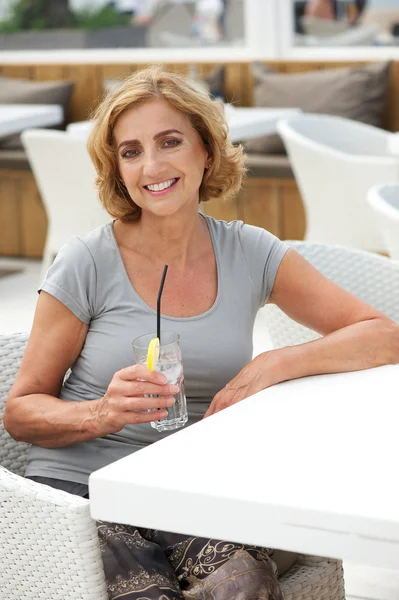 Retrato de una hermosa mujer sonriendo con bebida en el restaurante — Foto de Stock