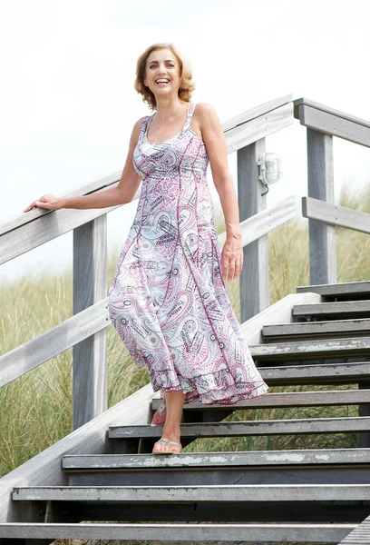 Woman smiling and walking downstairs outdoors — Stock Photo, Image