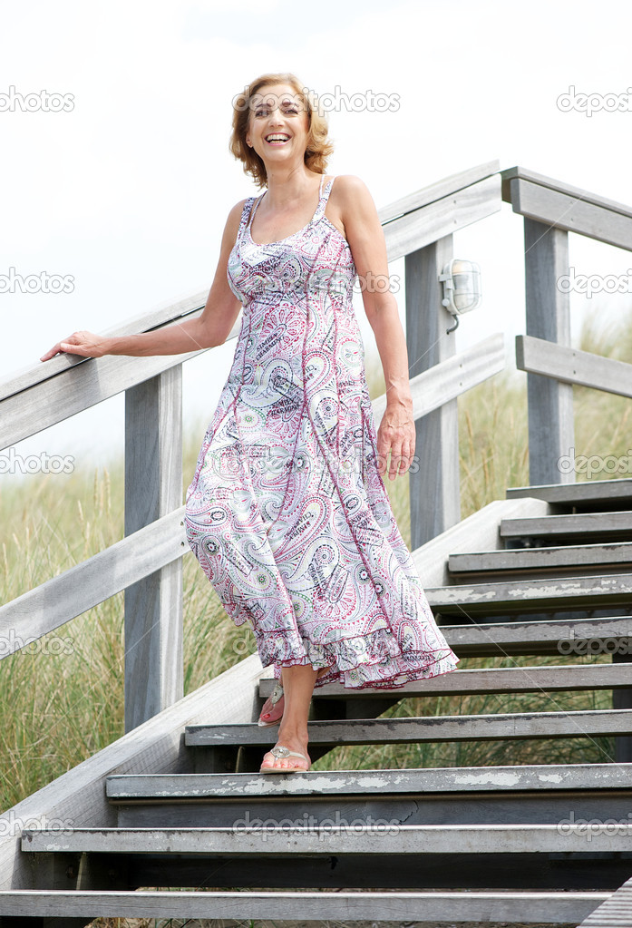 Woman smiling and walking downstairs outdoors