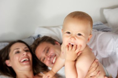 bebekle birlikte gülerek mutlu bir aile portresi