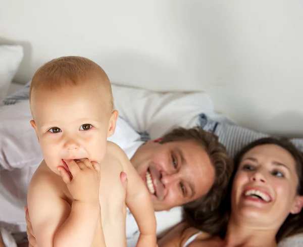 Birlikte gülümseyen genç mutlu bir aile portresi — Stok fotoğraf