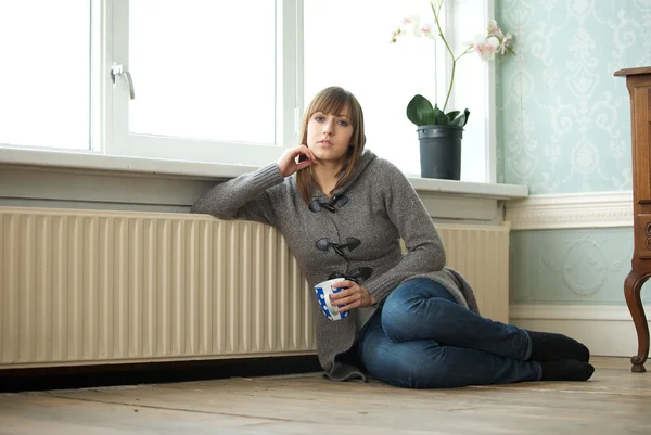 Jeune femme relaxante à la maison avec une tasse de café — Photo