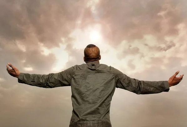 Hombre con los brazos extendidos mirando al cielo —  Fotos de Stock