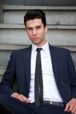 merdivenlerde oturan çekici erkek moda model