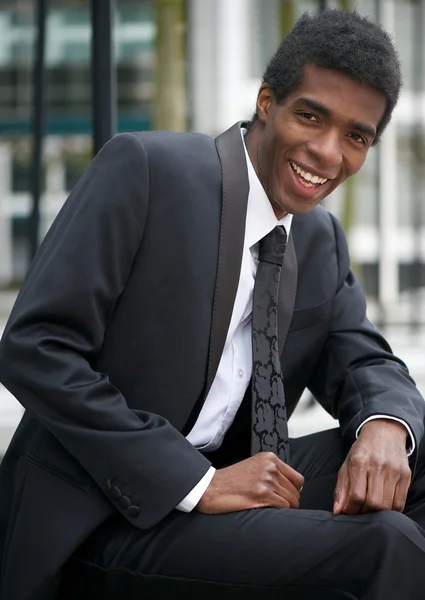 Portrét pohledný muž sedí venku v obleku — Stock fotografie