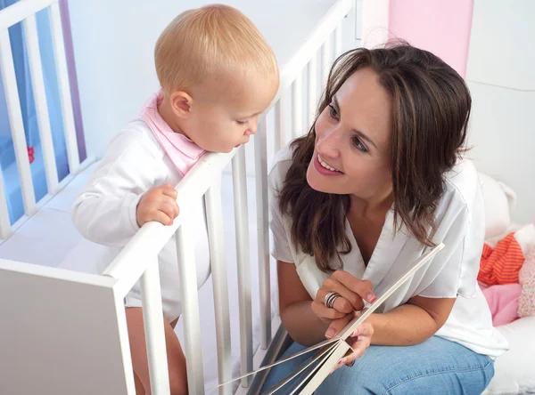 Porträtt av en vacker mor läsa bok att söt baby — Stockfoto