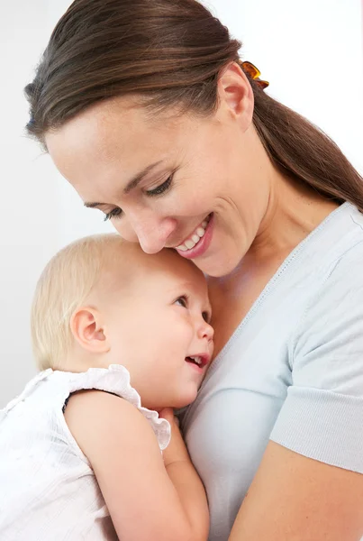 Retrato de uma mãe feliz abraçando bebê bonito — Fotografia de Stock