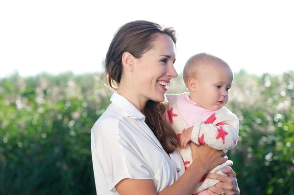 Mãe bonita sorrindo e segurando bebê bonito — Fotografia de Stock