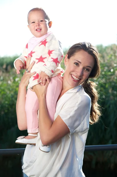 Attraktiv kvinna ler med happy baby — Stockfoto