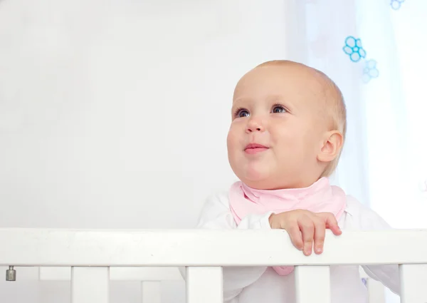 Retrato de um bebê adorável em pé no berço — Fotografia de Stock