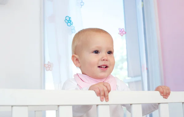 Retrato de un lindo bebé sonriendo en la cuna — Foto de Stock