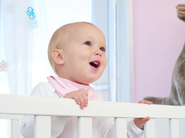 Retrato de un bebé feliz sonriendo en la cuna — Foto de Stock