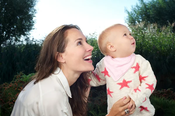 Bela jovem mãe olhando para longe com bebê bonito ao ar livre — Fotografia de Stock