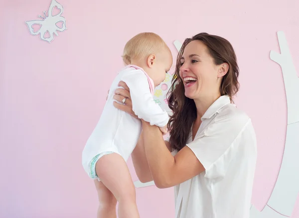 Retrato de madre feliz sosteniendo bebé lindo en casa — Foto de Stock