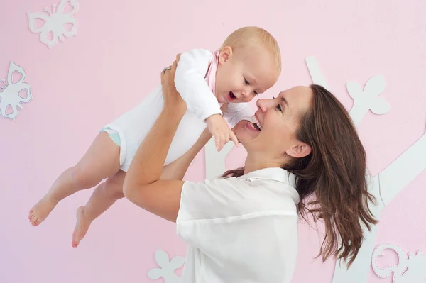 Porträtt av en glad mamma leker med söt baby — Stockfoto