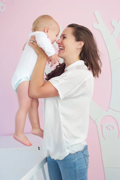 Cheerful mother hugging cute baby at home — Stock Photo, Image