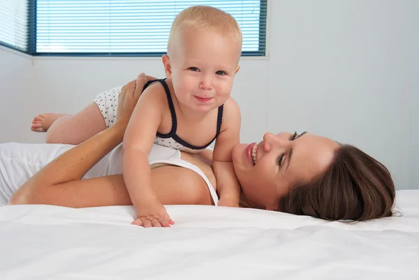 Schattige baby samen met gelukkige jonge moeder — Stockfoto