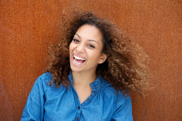 Веселая молодая женщина улыбается с вьющимися волосами — стоковое фото