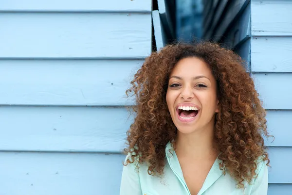 Vrolijke jonge vrouw lachen buitenshuis — Stockfoto