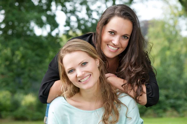 Portret van twee volwassen zuster lachend samen buitenshuis — Stockfoto