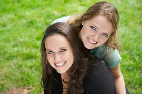 Portrait of two beautiful girls smiling outdoors — Stock Photo, Image