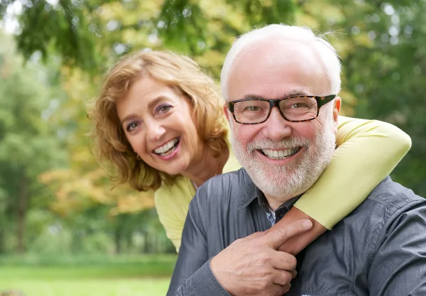 Glad äldre kvinna omfamnar leende äldre man — Stockfoto