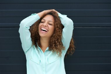 Cheerful young woman laughing with happy expression