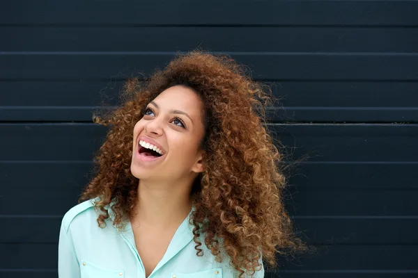 Beautiful young woman laughing outdoors and looking up — Stock Photo, Image