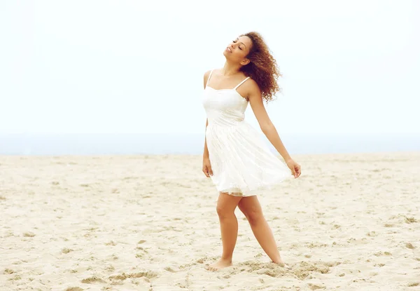 Όμορφη νεαρή γυναίκα περπάτημα στην παραλία σε λευκό φόρεμα — Φωτογραφία Αρχείου