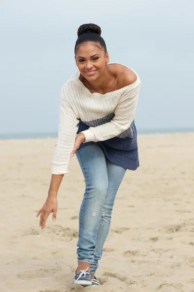 Atractiva joven mujer sonriendo y caminando en la playa —  Fotos de Stock